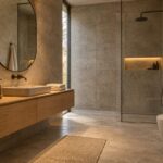 Bagno in stile brutalista caldo con gres effetto cemento, mobile lavabo in rovere e luce a 2700 K