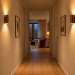 Corridoio stretto illuminato da due applique con fasci caldi sulle pareti
