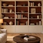 Libreria chiara con retro rosso cuoio in un soggiorno dai toni caldi
