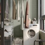 Scaffale JOSTEIN di IKEA con stendibiancheria aperto accanto alla lavatrice