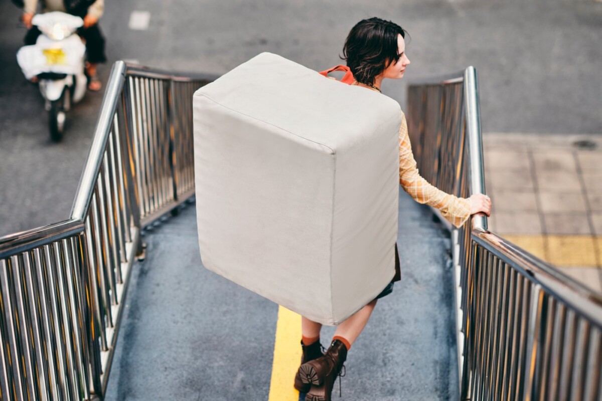Una persona trasporta il materasso pouf IKEA KOMPISHÄNG sulle scale con le cinghie