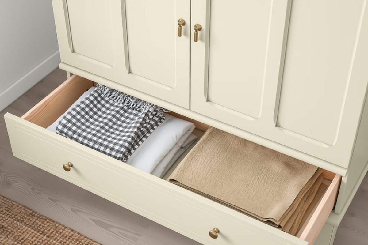 Cassetto aperto della credenza LOMMARP beige chiaro di IKEA con tessili piegati